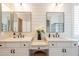 Modern bathroom with dual sinks, white cabinets, and wainscotting at 4235 S Snowcap Dr, Gilbert, AZ 85297