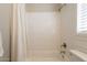 Bathroom with white subway tile walls, shower curtain, and a combined tub and shower at 4235 S Snowcap Dr, Gilbert, AZ 85297