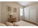 Bright bedroom featuring a bed, side table with lamp, and sliding door closet with neutral decor and hardwood flooring at 4235 S Snowcap Dr, Gilbert, AZ 85297