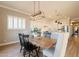 Bright dining area with wood floors, modern light fixture, and open to the kitchen at 4235 S Snowcap Dr, Gilbert, AZ 85297
