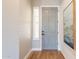 Welcoming entryway featuring a light gray front door, wood-look floors, wainscotting, and stylish decor at 4235 S Snowcap Dr, Gilbert, AZ 85297