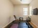 Well-lit exercise room with rubber flooring, weight bench, free weights, and a wall-mounted television at 4235 S Snowcap Dr, Gilbert, AZ 85297