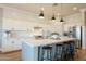 Well-lit kitchen features white cabinets, tile backsplash, stainless appliances, and center island with seating at 4235 S Snowcap Dr, Gilbert, AZ 85297