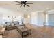 Open-concept living room featuring hardwood floors and a large ceiling fan, flowing into the kitchen and entryway at 4235 S Snowcap Dr, Gilbert, AZ 85297