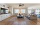 Spacious living room featuring hardwood floors, a neutral color palette, a large ceiling fan, and ample natural light at 4235 S Snowcap Dr, Gilbert, AZ 85297