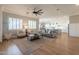 Bright living room showcasing hardwood floors, a ceiling fan, and seamlessly connects to the kitchen and dining areas at 4235 S Snowcap Dr, Gilbert, AZ 85297