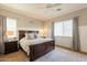 Comfortable main bedroom featuring a dark wood bed frame, a ceiling fan, and ample natural light at 4235 S Snowcap Dr, Gilbert, AZ 85297