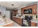 Kitchen view features stainless steel appliances, dark wood cabinets and tile counter tops at 4403 N 48Th Dr, Phoenix, AZ 85031