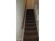 Carpeted staircase with a wooden handrail providing access to the upper levels of the home at 4465 E Paradise Village S Pkwy # 1200, Phoenix, AZ 85032