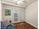 Cozy bedroom showcasing a ceiling fan, hardwood floors, and bright white double doors with backyard views at 6035 N 9Th Ave, Phoenix, AZ 85013
