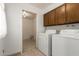 Bright laundry room with a washer, dryer, overhead cabinets, and a doorway to an adjacent room at 6035 N 9Th Ave, Phoenix, AZ 85013