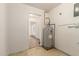 Simple utility room showing a water heater and a doorway to another room with light streaming through shutters at 6035 N 9Th Ave, Phoenix, AZ 85013