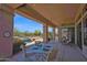 Covered back patio with a dining table, seating, and a view of the pool and desert landscape at 7283 E Brisa Dr, Scottsdale, AZ 85266