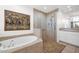 Luxurious bathroom featuring a soaking tub, walk-in shower with beautiful tile work, and a vanity with white cabinets at 7283 E Brisa Dr, Scottsdale, AZ 85266
