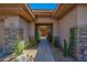 Inviting covered walkway leading to a stunning front door framed by desert plants and stone columns at 7283 E Brisa Dr, Scottsdale, AZ 85266