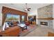 Comfortable living room with a stone fireplace, leather seating, and sliding glass doors to the backyard pool area at 7283 E Brisa Dr, Scottsdale, AZ 85266