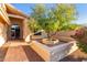 Landscaped front entrance featuring brickwork, decorative trees, and black metal security gate at 8061 E Lavender Dr, Gold Canyon, AZ 85118