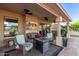 Covered patio offering comfortable seating around a gas fire pit and views of the backyard at 8061 E Lavender Dr, Gold Canyon, AZ 85118