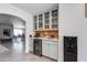 Elegant bar area with glass-front cabinets, beverage refrigerator, and stylish countertop space at 8219 N 3Rd Ave, Phoenix, AZ 85021