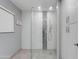 Bathroom featuring glass shower, textured tile, and storage cabinets in neutral tones at 8219 N 3Rd Ave, Phoenix, AZ 85021