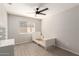 Bright bedroom featuring a window, modern ceiling fan, and gray wood-look flooring at 8343 W Paradise Dr, Peoria, AZ 85345
