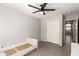 Clean bedroom with ceiling fan, gray wood-look floors, and closet with bi-fold doors at 8343 W Paradise Dr, Peoria, AZ 85345
