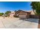 View of the house from a driveway with desert landscaping and a two-car garage at 8343 W Paradise Dr, Peoria, AZ 85345