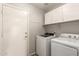 Functional laundry room with modern washer and dryer and practical storage cabinets at 8343 W Paradise Dr, Peoria, AZ 85345