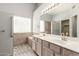 Well-lit main bathroom featuring dual sinks, a large mirror, and accessible shower at 8343 W Paradise Dr, Peoria, AZ 85345