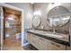 Modern bathroom featuring a double sink vanity with travertine countertops, modern fixtures, and a tiled shower at 8880 E Paraiso Dr # 120, Scottsdale, AZ 85255