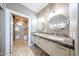 Bathroom featuring double sinks, marble countertops, and tiled shower with glass doors at 8880 E Paraiso Dr # 120, Scottsdale, AZ 85255