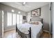 Well-lit bedroom with a ceiling fan, travertine floors, and plantation shutters on the windows at 8880 E Paraiso Dr # 120, Scottsdale, AZ 85255