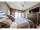 Cozy bedroom featuring shutters, ceiling fan, and dark wood dresser with television at 8880 E Paraiso Dr # 120, Scottsdale, AZ 85255
