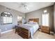 Comfortable bedroom featuring a wood bed frame, travertine floors, and a view into the bathroom at 8880 E Paraiso Dr # 120, Scottsdale, AZ 85255