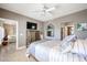 Bedroom featuring a ceiling fan, travertine floors, and a view into the living room and bathroom at 8880 E Paraiso Dr # 120, Scottsdale, AZ 85255