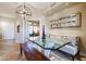 Dining area featuring modern light fixture and glass table, with a view leading into an office at 8880 E Paraiso Dr # 120, Scottsdale, AZ 85255