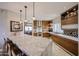 Modern kitchen with stainless steel appliances, wood cabinets, and a large marble island with seating at 8880 E Paraiso Dr # 120, Scottsdale, AZ 85255