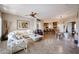 Spacious living room with travertine floors, a modern chandelier, and an open floor plan to the kitchen at 8880 E Paraiso Dr # 120, Scottsdale, AZ 85255