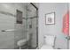 Modern bathroom featuring glass enclosed shower with stone tile surround and built in shelf, and updated toilet at 10124 E Michigan Ave, Sun Lakes, AZ 85248