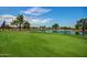 Scenic view of the lush green golf course with water features and trees at 10124 E Michigan Ave, Sun Lakes, AZ 85248