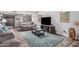 Comfortable living room with a large rug, television and view to the dining room at 10124 E Michigan Ave, Sun Lakes, AZ 85248