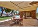 An outdoor patio with tables, chairs, and a view of the pool and grassy area at 10124 E Michigan Ave, Sun Lakes, AZ 85248