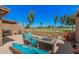 Inviting patio area with cushioned seating, fire pit and barbeque with manicured lawn in the background at 10124 E Michigan Ave, Sun Lakes, AZ 85248