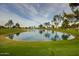 Scenic view of a pond surrounded by manicured green lawn and trees at 10124 E Michigan Ave, Sun Lakes, AZ 85248