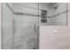 Modern shower with sleek glass enclosure, grey tile surround and hexagon tiled floor at 10124 E Michigan Ave, Sun Lakes, AZ 85248