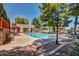 Community swimming pool with lounge chairs and shaded seating areas, surrounded by landscaping at 10124 E Michigan Ave, Sun Lakes, AZ 85248