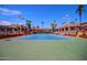 Community tennis court surrounded by buildings, with lighting and clear skies at 10124 E Michigan Ave, Sun Lakes, AZ 85248