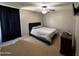 Cozy bedroom featuring a comfortable bed, a ceiling fan, and a dark wood dresser at 10347 W Odeum Ln, Tolleson, AZ 85353