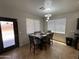 The dining room features a table with seating for six, tile floors and bright, natural light at 10347 W Odeum Ln, Tolleson, AZ 85353