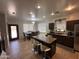 Open-concept kitchen and dining area features an island with barstool seating at 10347 W Odeum Ln, Tolleson, AZ 85353